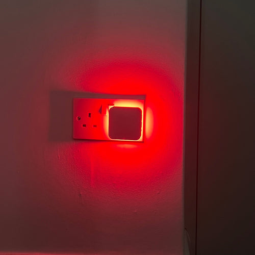 The Driftback night light lighting a hallway wall in soft red