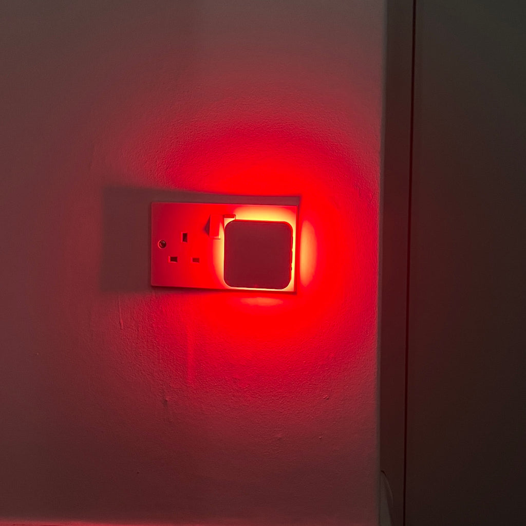 The Driftback night light lighting a hallway wall in soft red