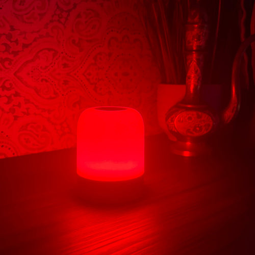 The Driftback sleep lamp glowing 670nm red on a bedside table